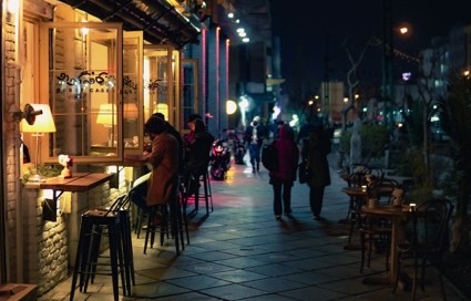 Uitgaansstraat met caf&eacute;s in de avond